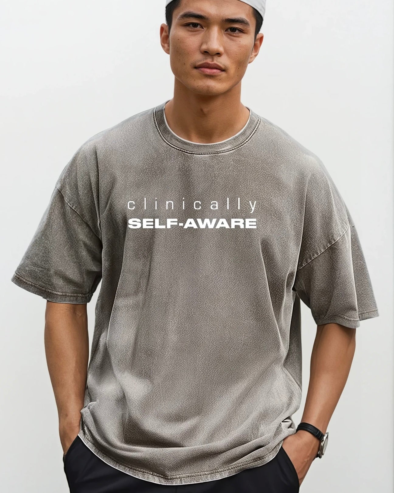 Person wearing a coffee color t-shirt with 'clinically self-aware' text on a white background