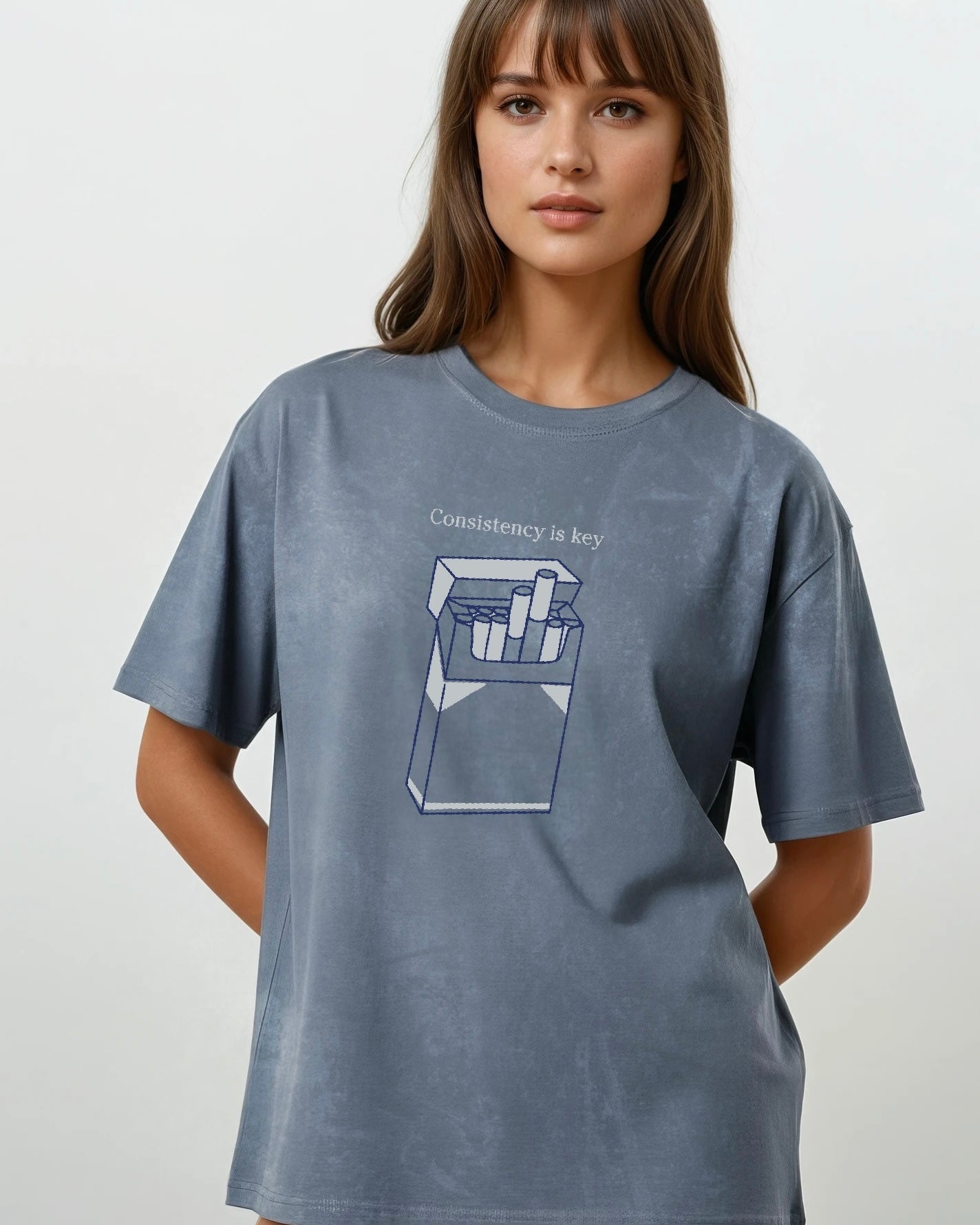 woman wearing an oversized vintage wash gray heavyweight cotton t-shirt with an embroidered graphic design that reads
