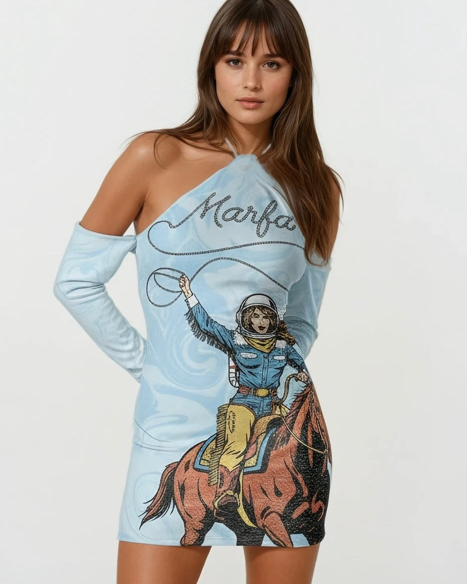 Woman wearing a light blue long sleeve halter dress with a graphic design of a cowgirl on a horse and the word 'Marfa' against a white background