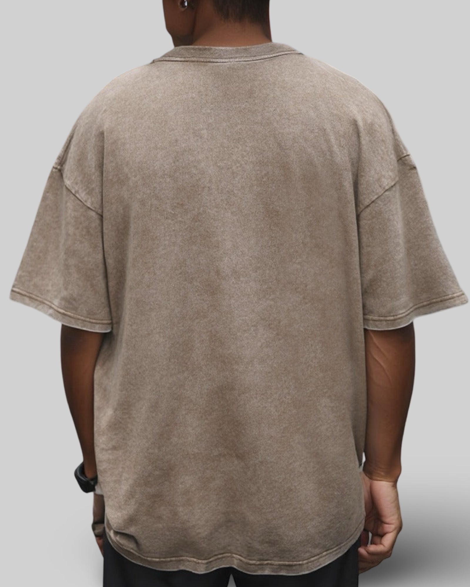 Back view of a person wearing a beige t-shirt on a plain background
