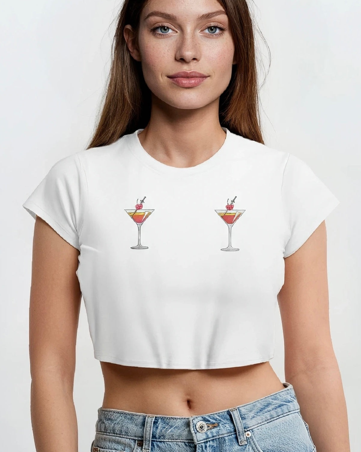 woman wearing a white cotton crop top baby tee with embroidered martini design across chest against a white background