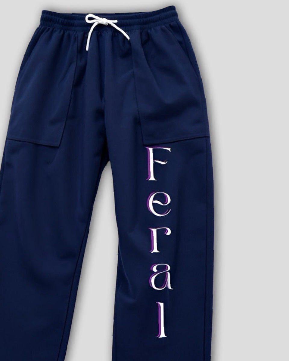 Navy blue sweatpants with 'Feral' printed in white on a light gray background