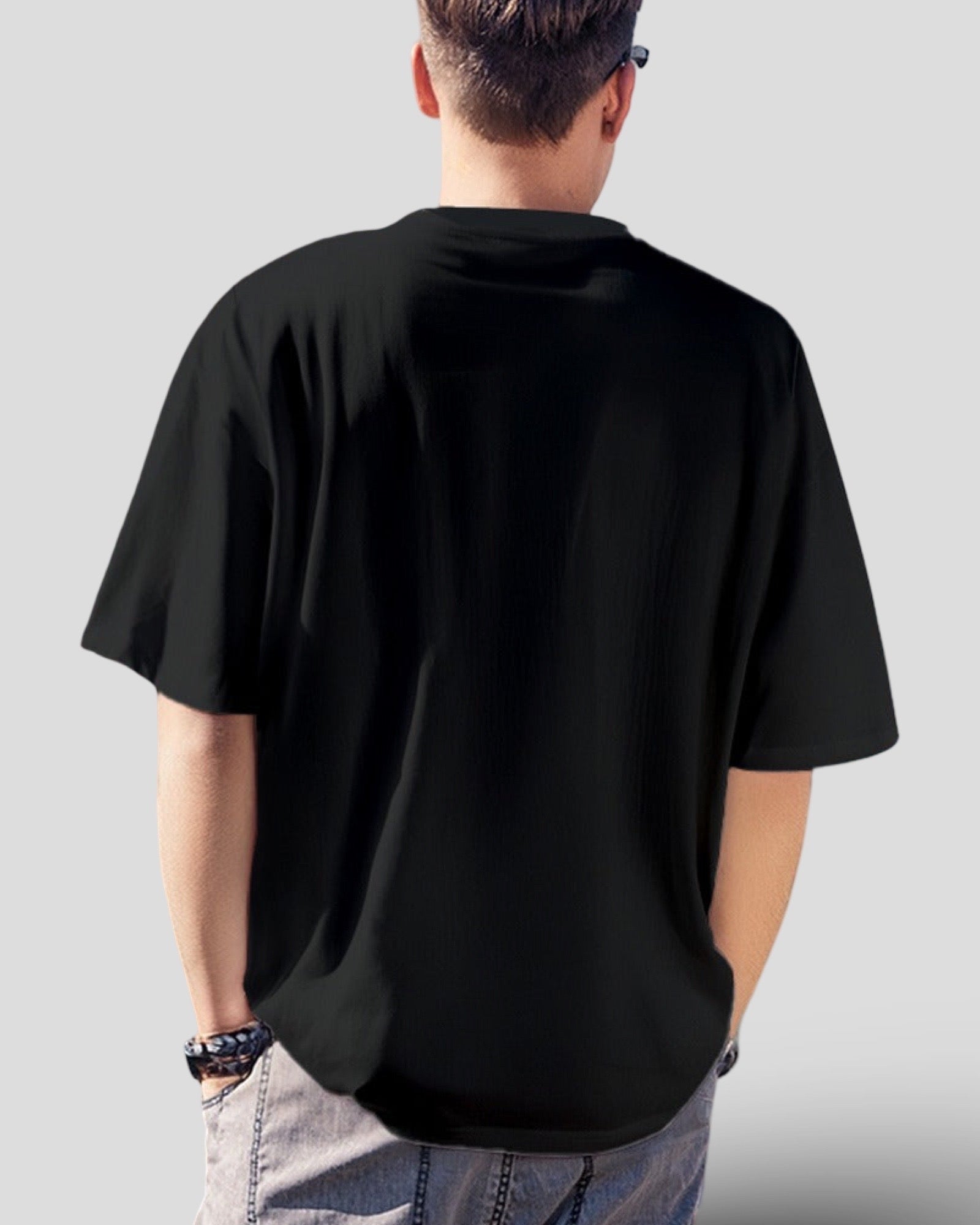 Person wearing a black cotton t-shirt on a plain background