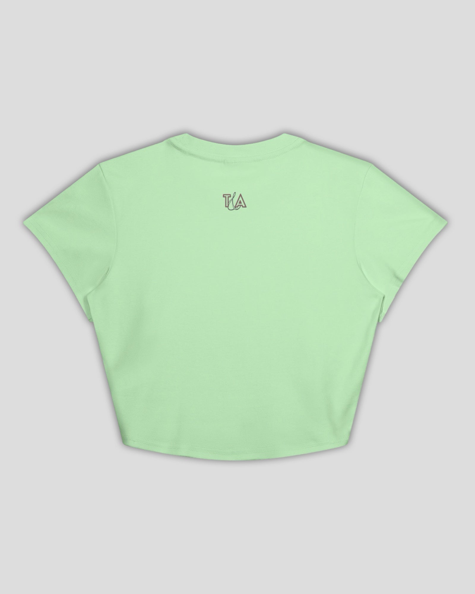 a flat lay image of a green cropped cotton t-shirt with a small T&A logo on the back against a white background