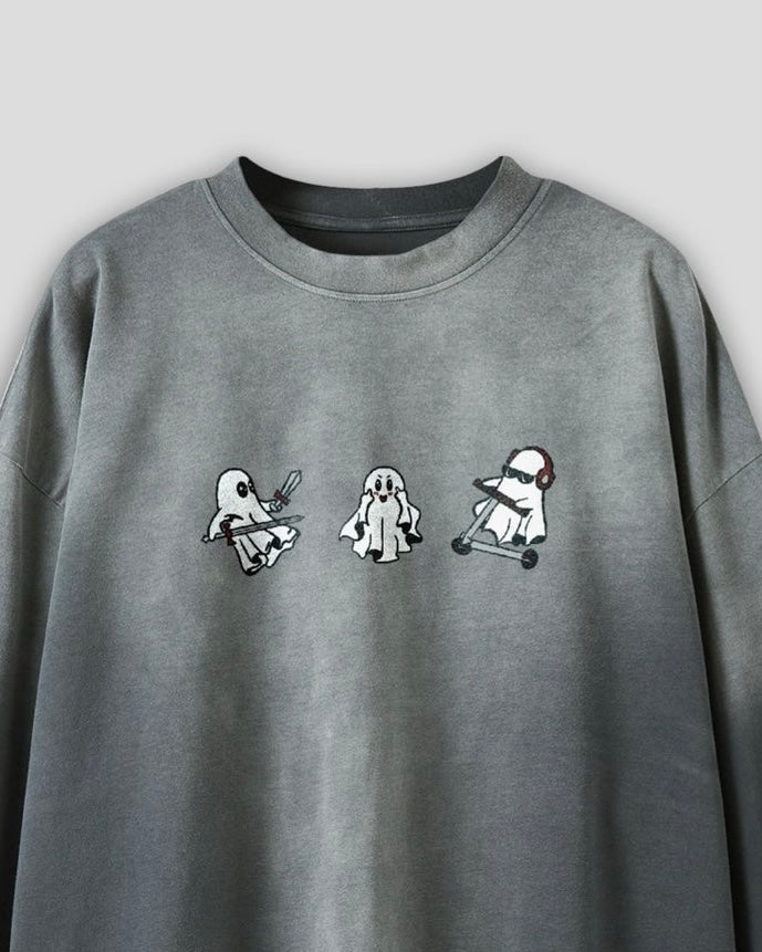 close up view of a long sleeve grey vintage washed heavyweight cotton t shirt with embroidered original ghost graphics and a small t&a logo against a white background