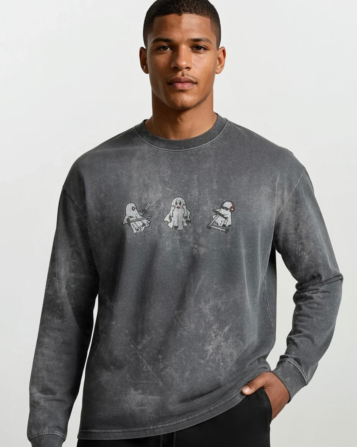 man wearing a long sleeve grey vintage washed heavyweight cotton t shirt with embroidered original ghost graphics and a small t&a logo against a white background