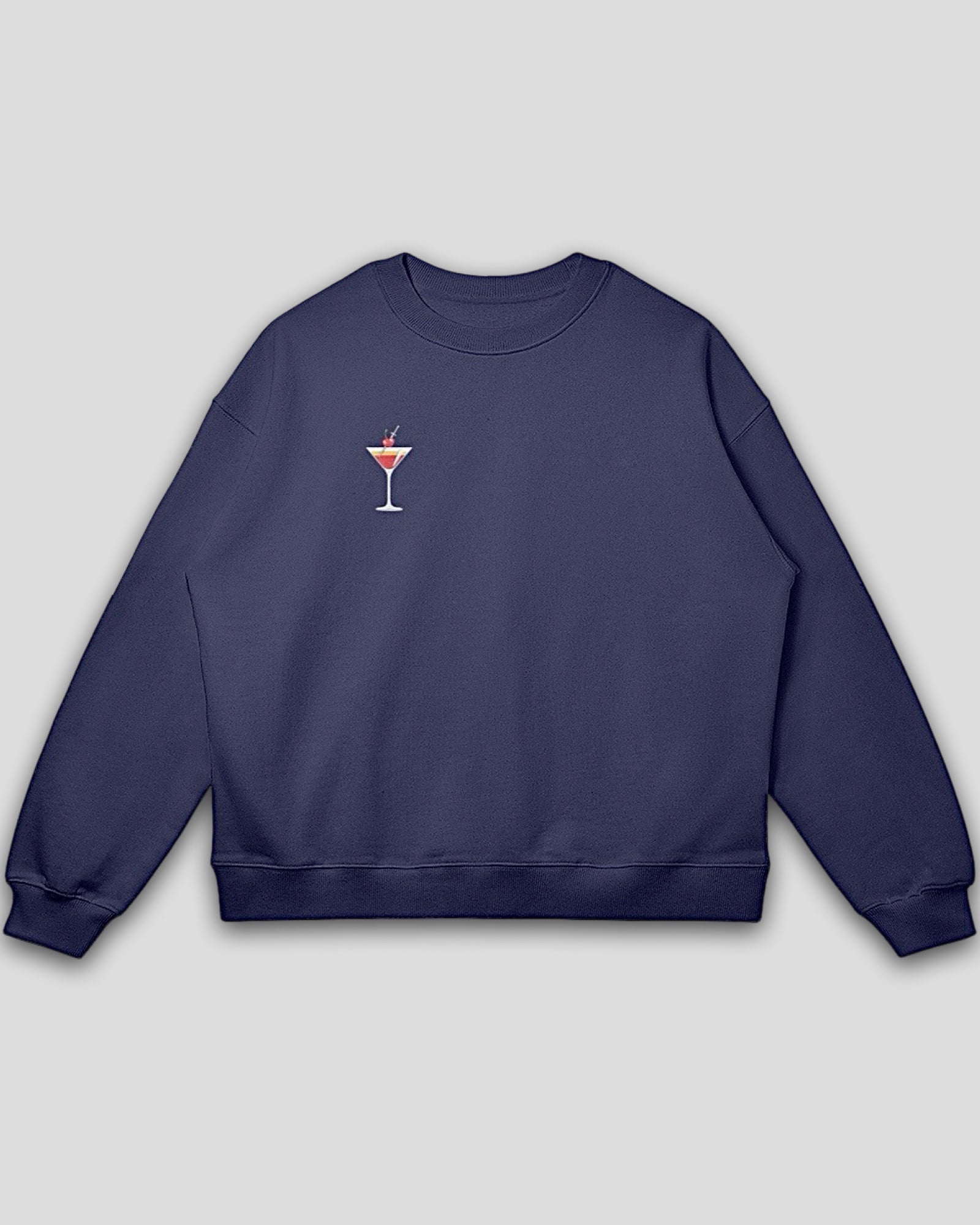 flat lay image of a navy blue oversized heavyweight cotton drop shoulder embroidered premium pullover sweatshirt with embroidered martini design against a white background