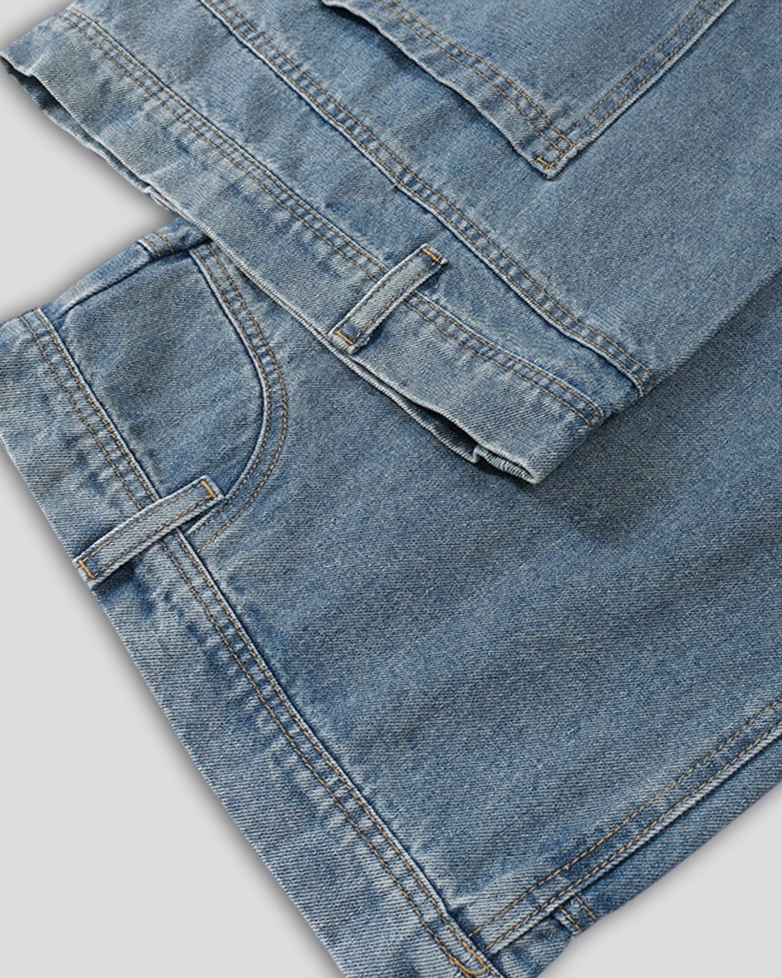 close up of light blue denim vintage washed jeans against a white background