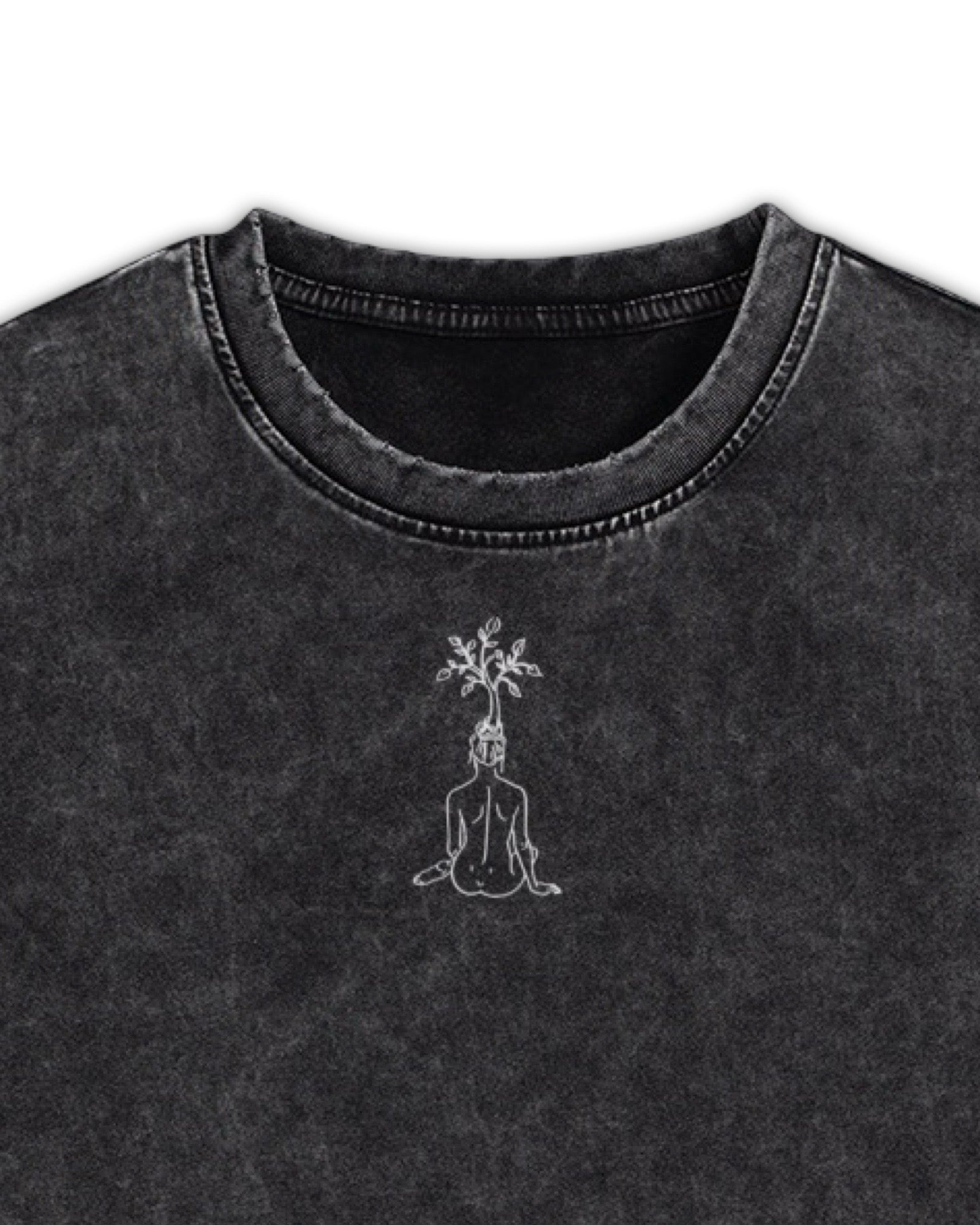 Close up of black t shirt with a washed finish featuring a white line graphic embroidery of a woman with a tree growing out of her head, displayed on a white background