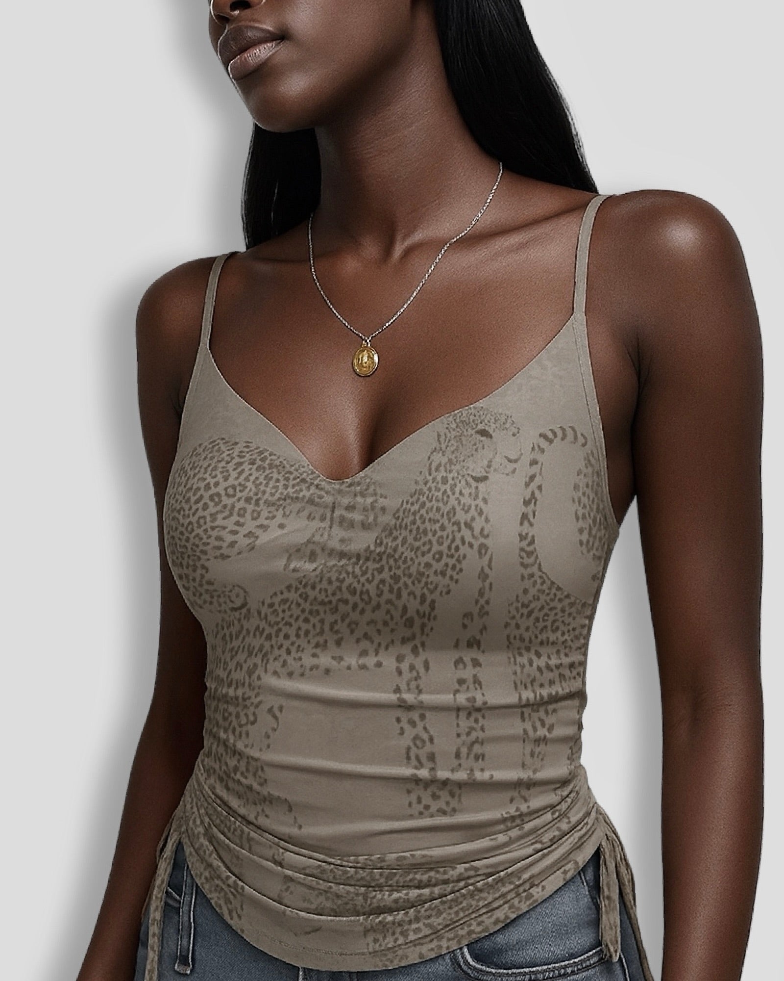 Woman wearing a beige neutral cheetah print cami top against a plain background