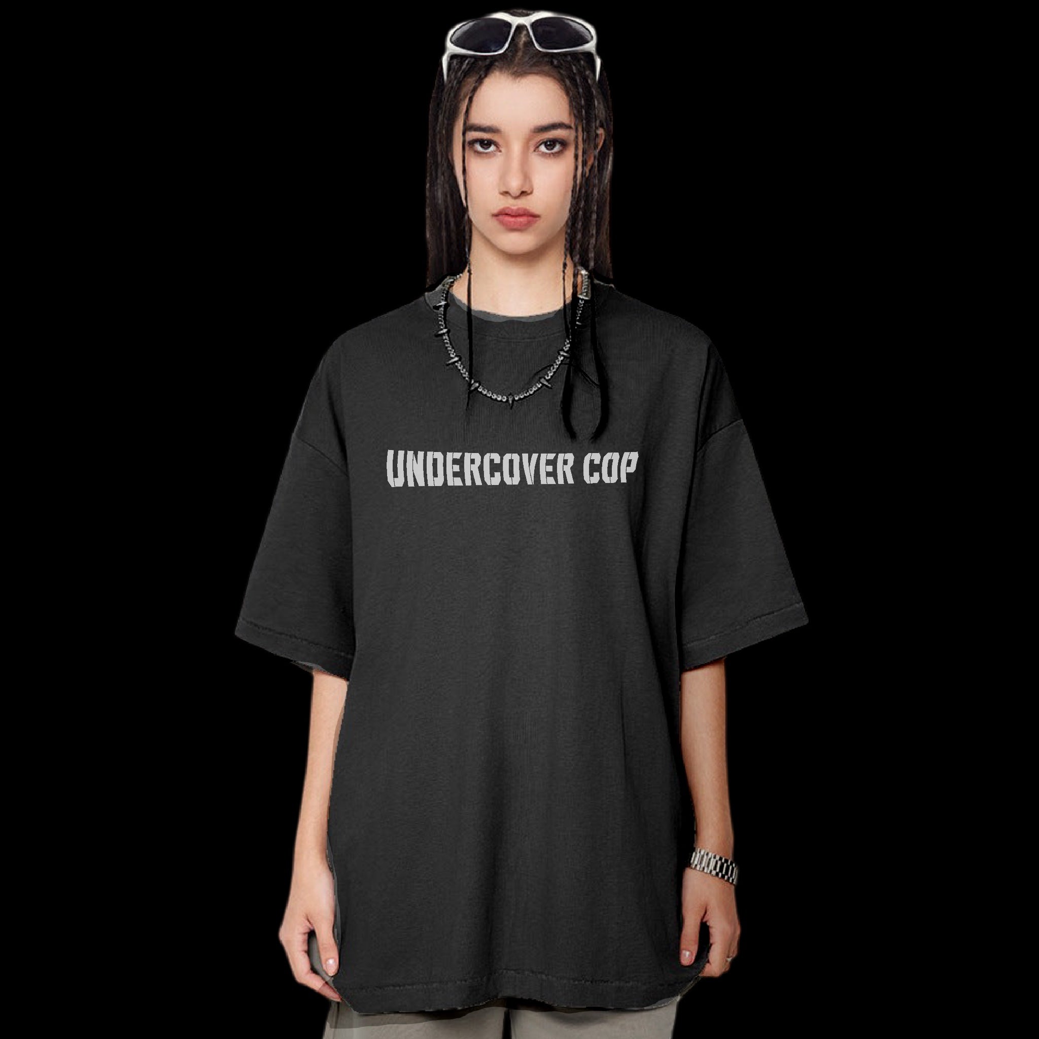 A person wearing a black oversized heavyweight cotton t-shirt with the text 'UNDERCOVER COP' on the front.